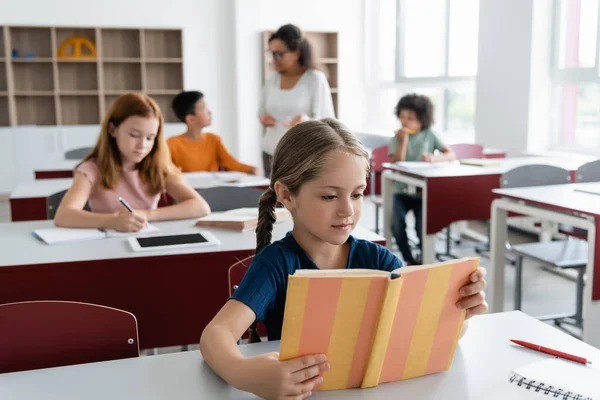 Girl Reading Book Multiethnic Classmates African American Teacher Blurred Background — Stock Photo, Image