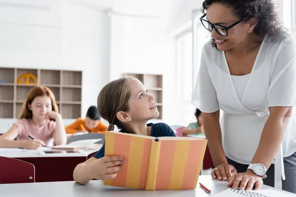 Glimlachend Schoolmeisje Afrikaanse Amerikaanse Leraar Kijken Naar Elkaar Buurt Wazig — Stockfoto