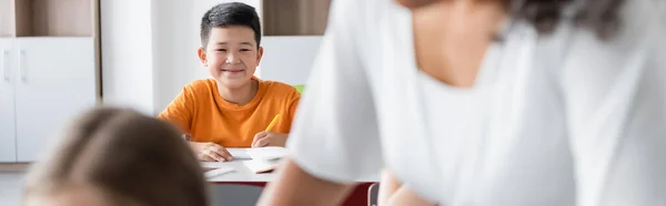 Fröhlicher Asiatischer Schuljunge Blickt Die Kamera Der Nähe Des Lehrers — Stockfoto