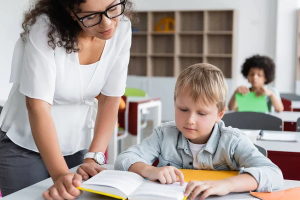 Afrikanisch Amerikanisch Lehrer Und Schoolboy Looking Buch Während Unterricht — Stockfoto