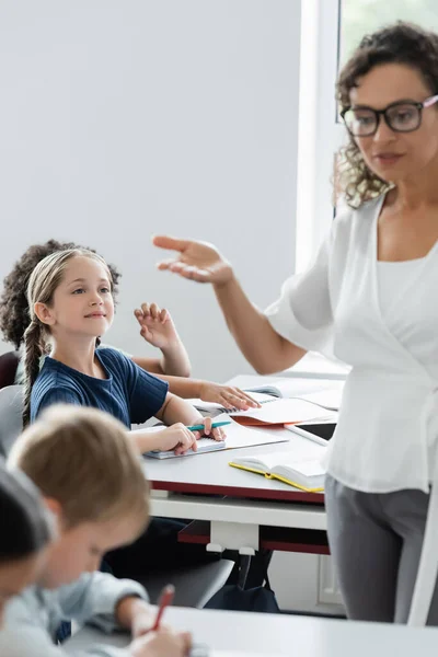 Blurred African American Teacher Pointing Hand While Talking Pupils Classroom — Stock Photo, Image