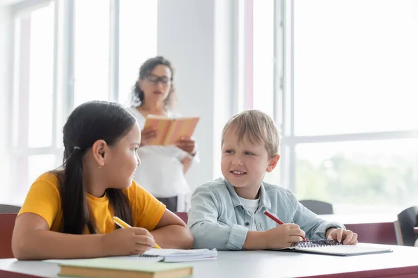 Interrassische Schüler Die Einander Beim Schreiben Von Diktaten Fast Verschwommen — Stockfoto