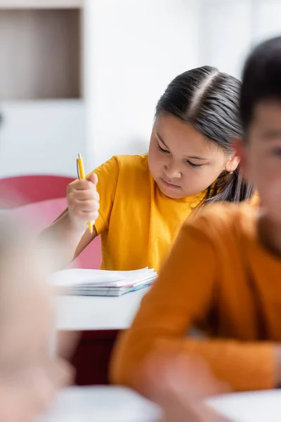 Asian Girl Holding Pen Notebook Blurred Classmates — Stock Photo, Image