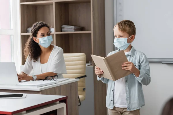 Scolaro Maschera Medica Lettura Libro Vicino Africano Americano Insegnante — Foto Stock