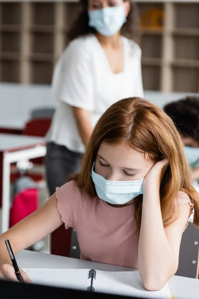 의료용 마스크를 여자가 아프리카 미국인 옆에서 공책을 있습니다 — 스톡 사진