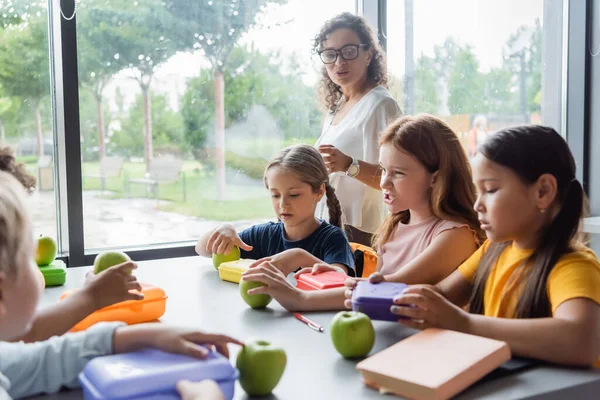 Afrikansk Amerikansk Lärare Pratar Med Multietniska Barn Lunchen Skolan Matsal — Stockfoto