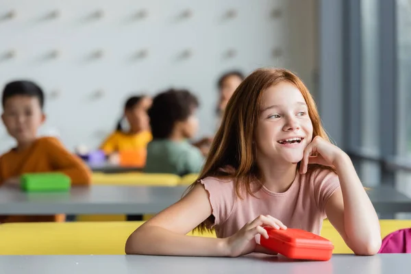 Счастливая Мечтательная Рыжеволосая Девушка Глядя Школьную Столовую Рядом Обеденной Коробкой — стоковое фото