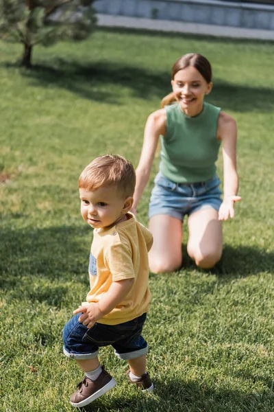 Mère Gaie Floue Avec Les Mains Tendues Assis Sur Herbe — Photo