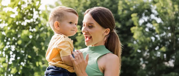 Förvånad Ung Mor Håller Vapen Småbarn Son Banderoll — Stockfoto