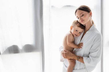 # Memnun ve dövmeli bir anne # # kucağında çıplak bir çocuk # 