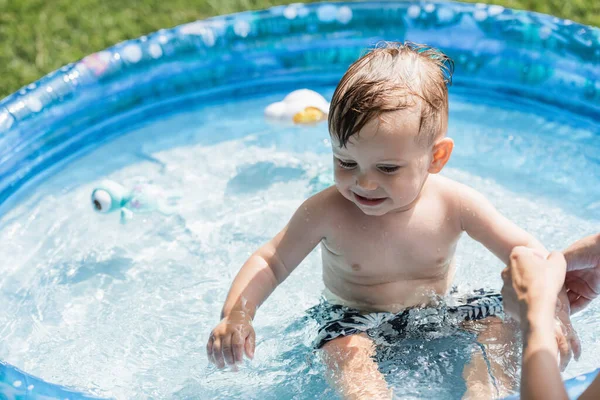 Madre Vicino Sorridente Figlio Seduto Piscina Gonfiabile Con Acqua Blu — Foto Stock