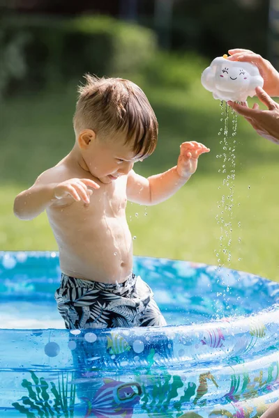 Bambino Ragazzo Piedi Piscina Gonfiabile Vicino Madre Versando Acqua Dal — Foto Stock