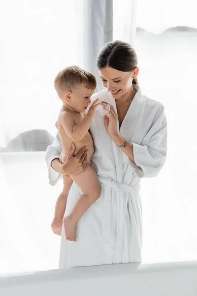 Cheerful Mother Bathrobe Holding Arms Naked Toddler Son Bathtub Bath — Stock Photo, Image