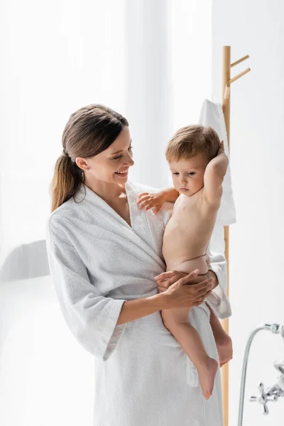 Sorrindo Mãe Roupão Segurando Nos Braços Descalço Filho Criança Nua — Fotografia de Stock