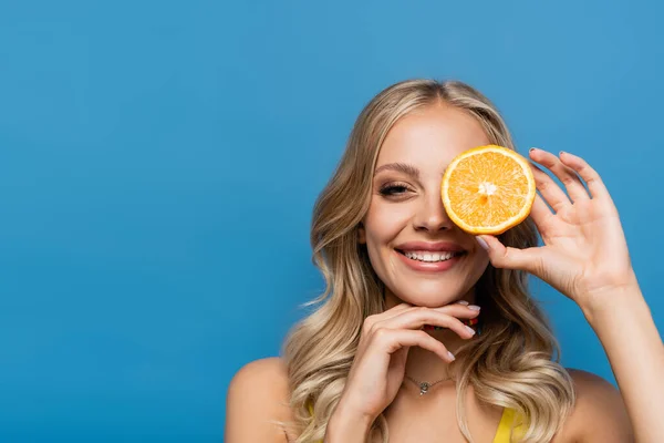 Cheerful Young Woman Covering Eye Orange Half Isolated Blue — Stock Photo, Image