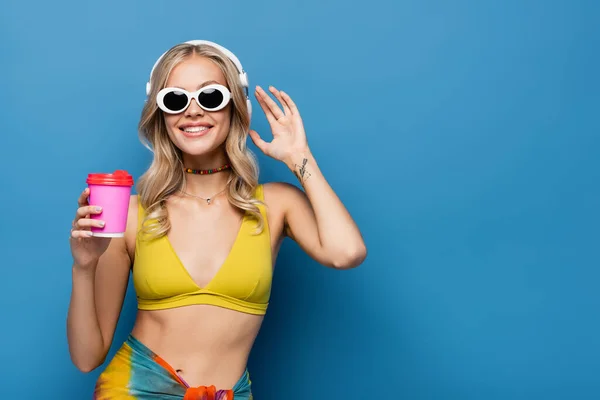 Sonriente Mujer Joven Auriculares Inalámbricos Bikini Superior Sosteniendo Taza Papel —  Fotos de Stock