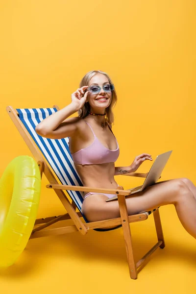 Smiling Woman Sunglasses Swimsuit Sitting Deck Chair Laptop Yellow — Stock Photo, Image