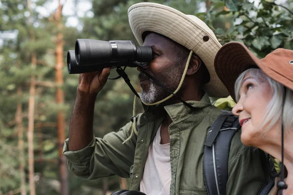 Africano Americano Excursionista Buscando Aunque Prismáticos Cerca Sonriente Esposa — Foto de Stock