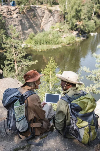 Senior Woman Backpack Looking African American Husband Digital Tablet Lake — Stock Photo, Image