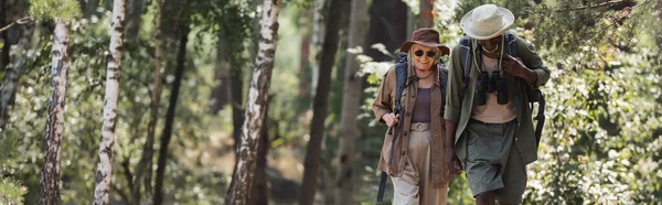 Smiling Elderly Woman Walking African American Husband Binoculars Backpack Forest — Stock Photo, Image