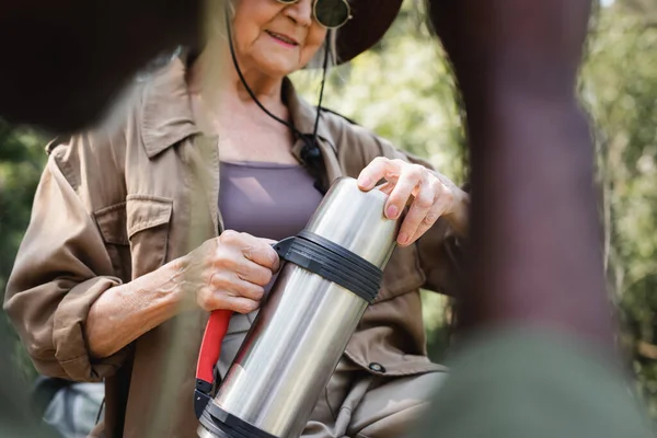 Cropped View Elderly Woman Holding Thermos Blurred African American Husband — Stock Photo, Image