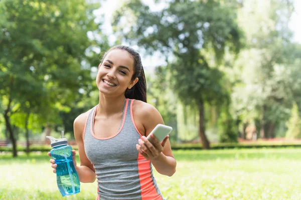 Happy Sportswoman Holding Sports Bottle Smartphone Park — Stock Photo, Image