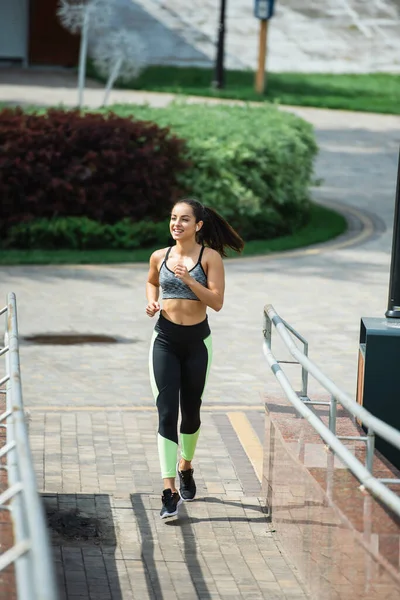 Full Length Cheerful Sportswoman Wireless Earphones Listening Music While Running — Stock Photo, Image