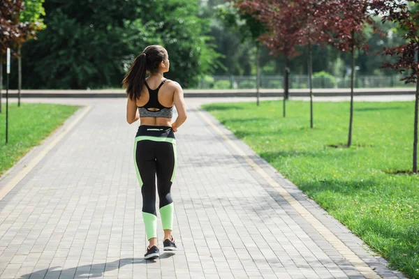 Vista Posteriore Donna Sportiva Auricolari Wireless Ascoltare Musica Durante Corsa — Foto Stock