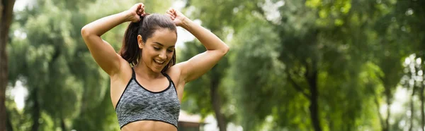 Happy Athletic Woman Crop Top Adjusting Ponytail Green Park Banner — Stock Photo, Image