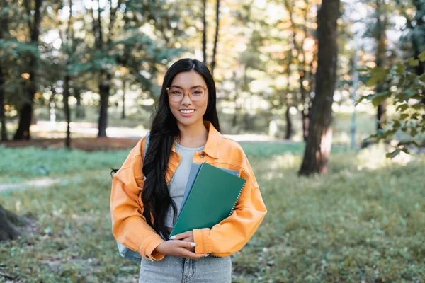 Veselý Asijský Student Notebooky Při Pohledu Kameru Parku — Stock fotografie
