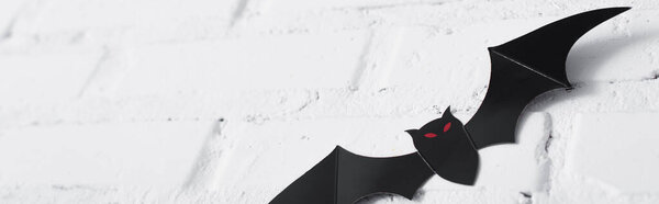 paper cut bat on white brick wall, banner