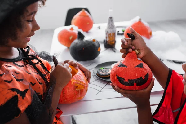 Felice Ragazza Afro Americana Guardando Disegno Sulla Zucca Vicino Fratello — Foto Stock