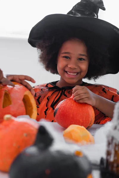 Lycklig Afrikansk Amerikansk Flicka Häxdräkt Nära Pumpor Och Suddig Bror — Stockfoto