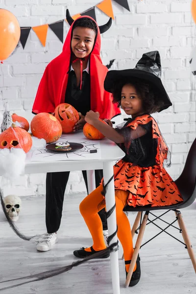 Africké Americké Děti Halloween Kostýmy Úsměvem Blízkosti Vyřezávané Dýně — Stock fotografie