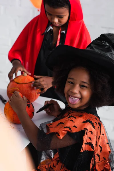 Happy African American Girl Witch Costume Sticking Out Tongue While — Stock Photo, Image