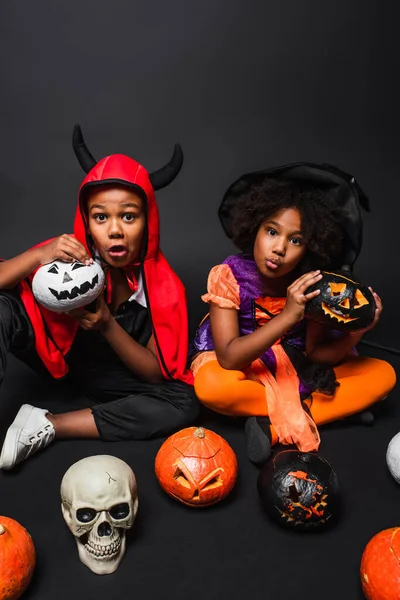 Espeluznantes Niños Afroamericanos Disfraces Halloween Sosteniendo Cráneo Escoba Cerca Calabazas — Foto de Stock