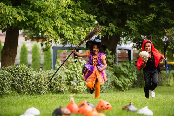 African American Kids Halloween Costumes Holding Brooms Running Backyard — Stock Photo, Image