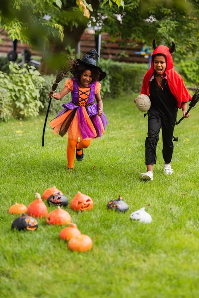 Opgewonden Afrikaanse Amerikaanse Kinderen Halloween Kostuums Met Bezems Draait Achtertuin — Stockfoto