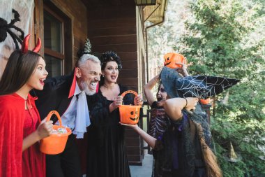 Evin yakınındaki çocukları korkutan ürkütücü cadılar bayramı kostümlü heyecanlı çift.
