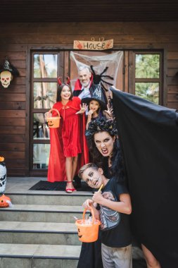 Ürkütücü anne ve oğlu Cadılar Bayramı kostümleriyle mutlu bir ailenin yanında suratlarını ekşitiyor.