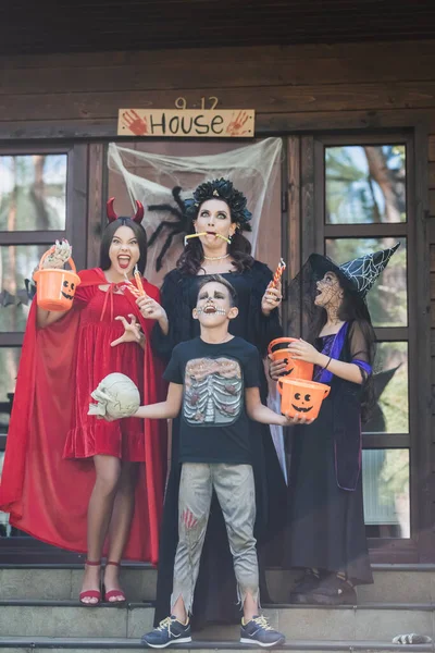 Spooky Family Halloween Costumes Holding Sweets Buckets Skull Decorated Porch — Stock Photo, Image