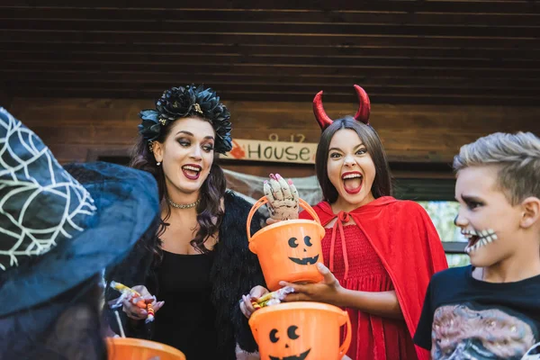 Mulher Com Doces Perto Crianças Animadas Segurando Baldes Gritando Trajes — Fotografia de Stock