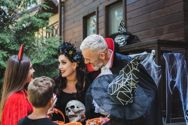 Šťastná Rodina Strašidelné Halloween Kostýmy Usmívat Blízkosti Dřevěného Domu — Stock fotografie