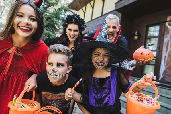 Vzrušená Rodina Děsivé Halloween Kostýmy Vrčení Kameru Zatímco Drží Vědra — Stock fotografie