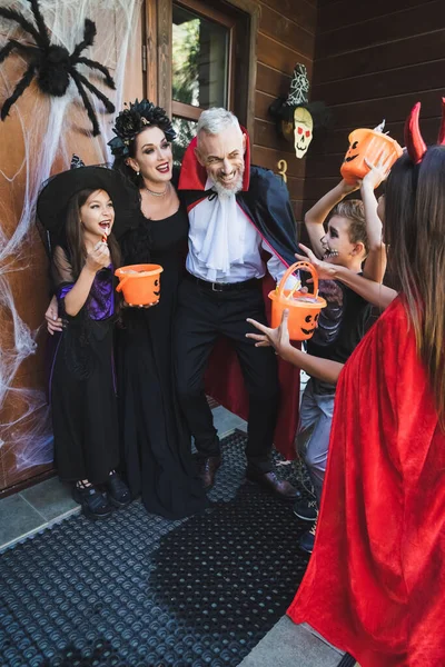 Happy Family Creepy Costumes Holding Buckets Sweets Porch Halloween Decoration — Stock Photo, Image