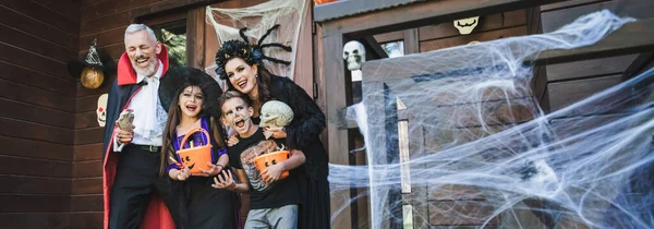 Vzrušená Rodina Úchylných Halloween Kostýmy Smějící Verandě Výzdobou Prapor — Stock fotografie