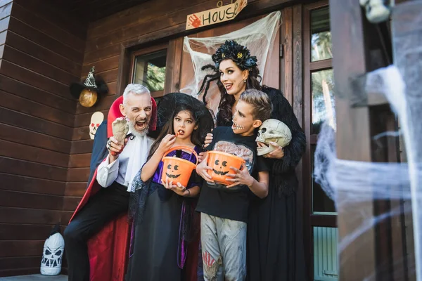 Hombre Sosteniendo Juguete Mano Mueca Cerca Familia Trajes Halloween — Foto de Stock