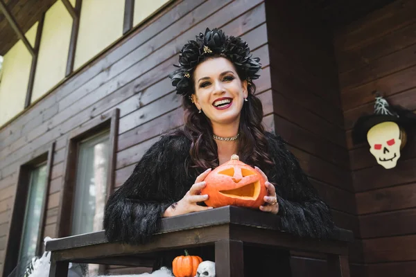 Cheerful Woman Black Halloween Dress Wreath Standing Wooden Balcony Carved — Stock Photo, Image