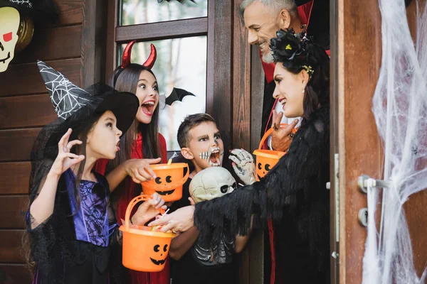 Děti Děsivých Halloweenských Kostýmech Držící Vědra Vrčící Usmívající Sousedy — Stock fotografie
