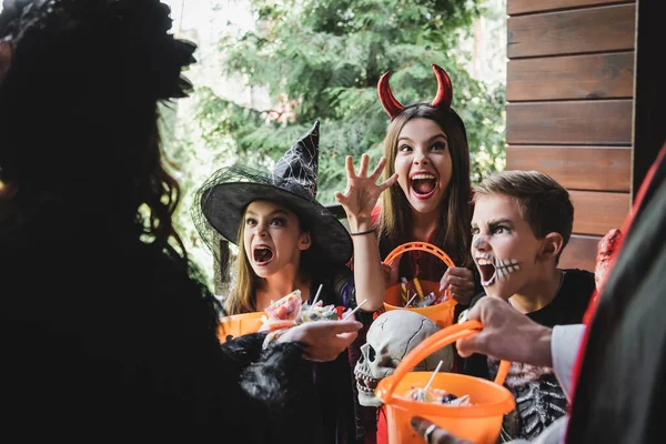 Strašidelné Děti Halloween Kostýmy Křičí Sousedy Drží Bonbóny Verandě — Stock fotografie